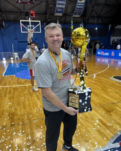 Fernando Jaeger com troféu de campeão em quadra de basquete